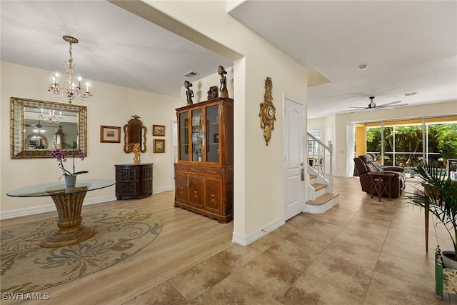 8840 Paseo De Valencia St, Fort Myers, FL 33908 - hallway with a notable chandelier, visible vents, stairway, light wood-type flooring, and baseboards