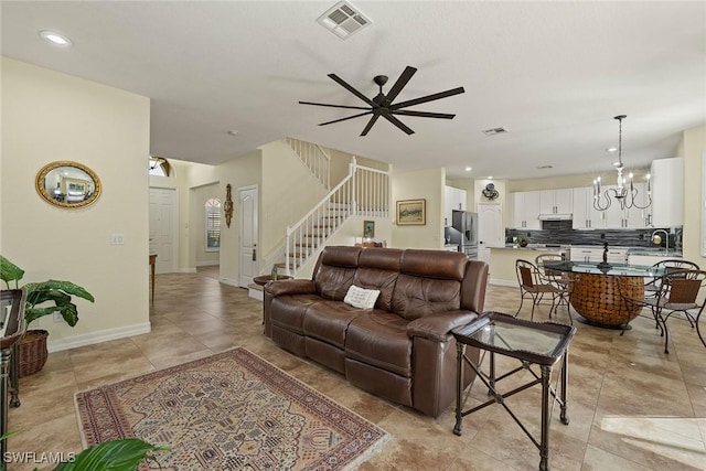 8840 Paseo De Valencia St, Fort Myers, FL 33908 - living room with baseboards, stairs, visible vents, and ceiling fan with notable chandelier