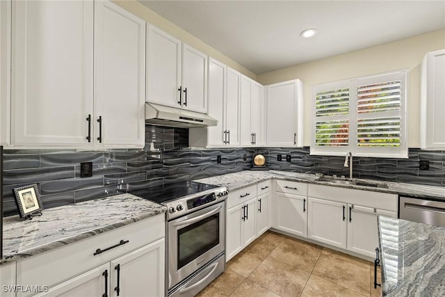 8840 Paseo De Valencia St, Fort Myers, FL 33908 - kitchen with backsplash, appliances with stainless steel finishes, white cabinets, a sink, and under cabinet range hood
