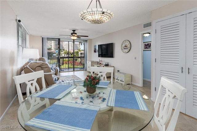 tiled dining area with a wall of windows and ceiling fan