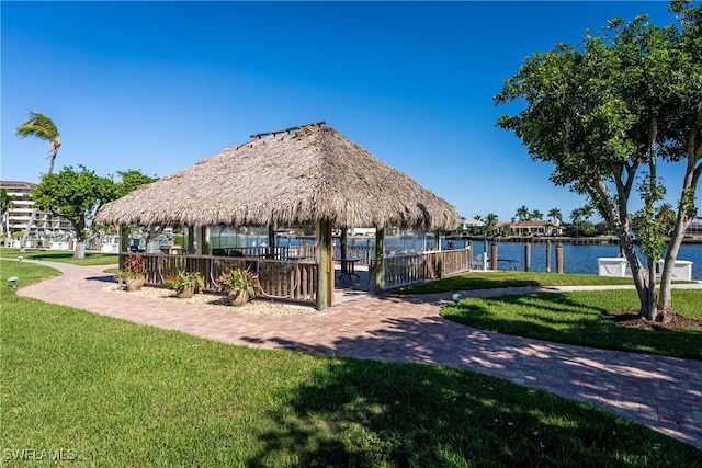 surrounding community with a water view, a gazebo, and a lawn