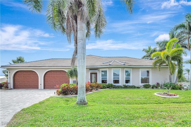 single story home featuring a garage, decorative driveway, a front yard, and stucco siding