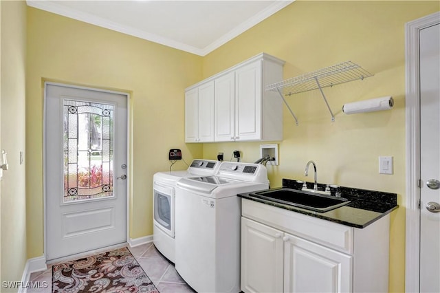 laundry area with cabinet space, light tile patterned floors, washing machine and clothes dryer, crown molding, and a sink