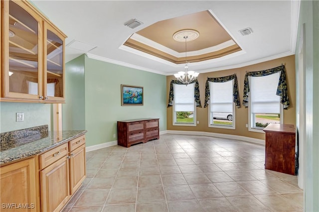 unfurnished dining area featuring plenty of natural light, visible vents, and a tray ceiling