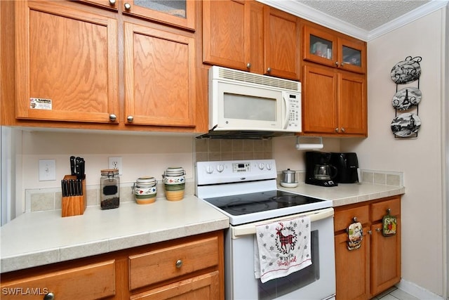 kitchen featuring white appliances, light countertops, ornamental molding, tasteful backsplash, and brown cabinetry