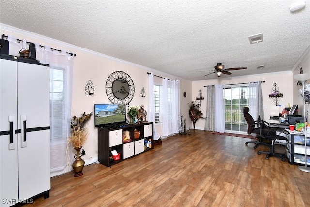 home office with a wealth of natural light, crown molding, visible vents, and wood finished floors