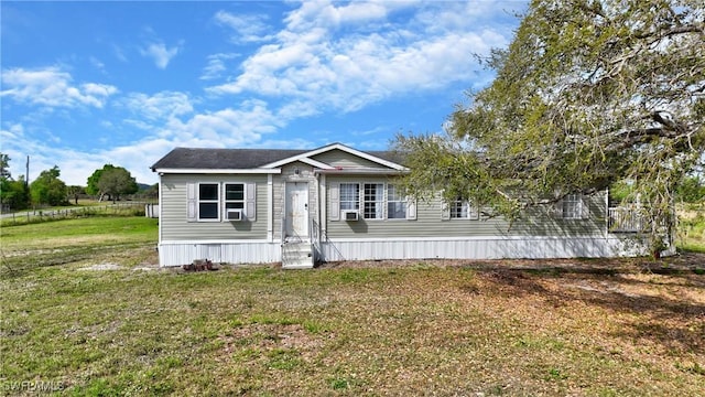 manufactured / mobile home with a front yard and cooling unit