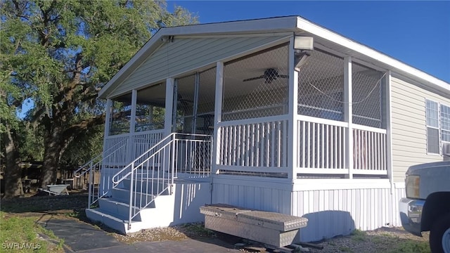 view of side of property with a sunroom and stairway