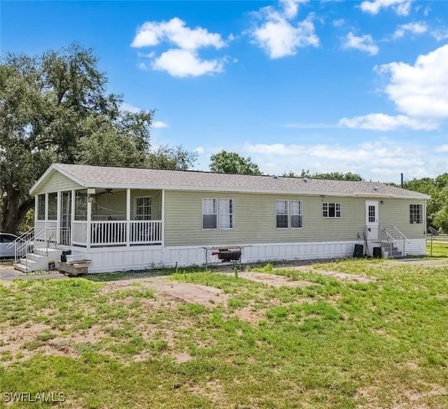 1132 W Red Rd, Labelle, FL 33935 - view of front of house featuring a sunroom, a front yard, and entry steps
