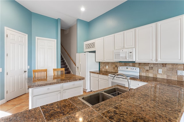 kitchen featuring white cabinetry, sink, white appliances, tasteful backsplash, and light tile patterned floors