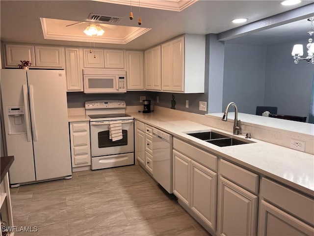 kitchen featuring hanging light fixtures, white appliances, white cabinets, a raised ceiling, and sink