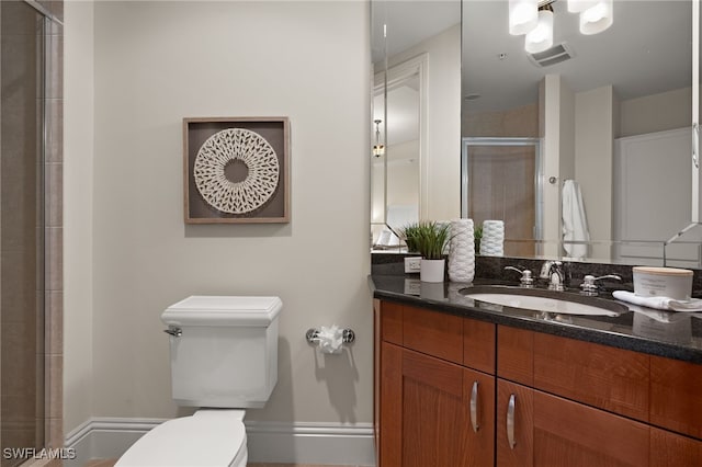 bathroom featuring toilet, visible vents, vanity, baseboards, and a stall shower