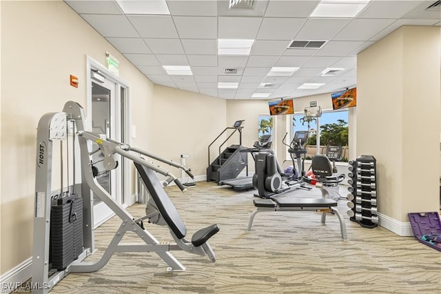 exercise room featuring a drop ceiling, carpet, visible vents, and baseboards