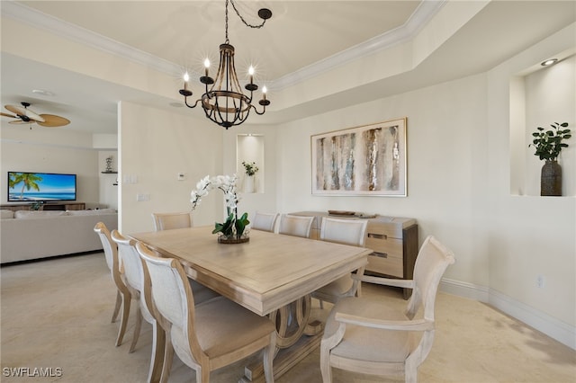 dining room featuring baseboards, ornamental molding, a raised ceiling, and ceiling fan with notable chandelier