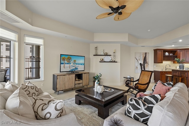 living area with recessed lighting, light carpet, ceiling fan, and baseboards