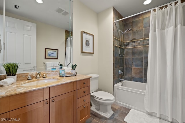 bathroom with toilet, vanity, visible vents, and tile patterned floors