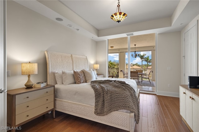 bedroom with access to outside, visible vents, dark wood finished floors, and baseboards