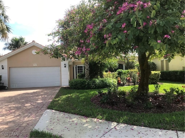 view of front of property with a garage, decorative driveway, and stucco siding