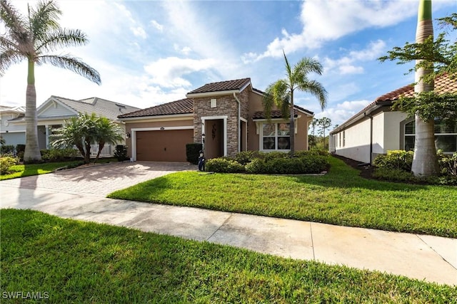 mediterranean / spanish house with a garage, driveway, stone siding, a tile roof, and a front lawn