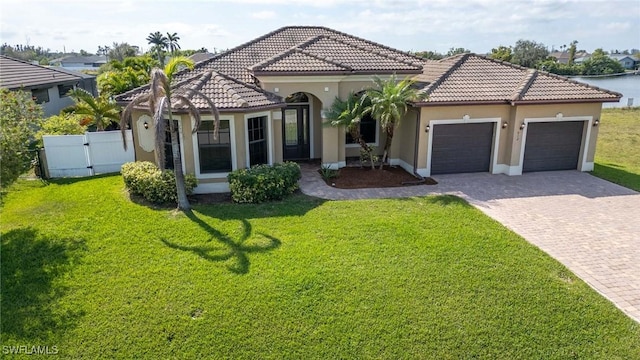 mediterranean / spanish-style home featuring a front yard and a garage