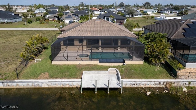 rear view of house featuring a pool with hot tub, a patio, glass enclosure, and a water view