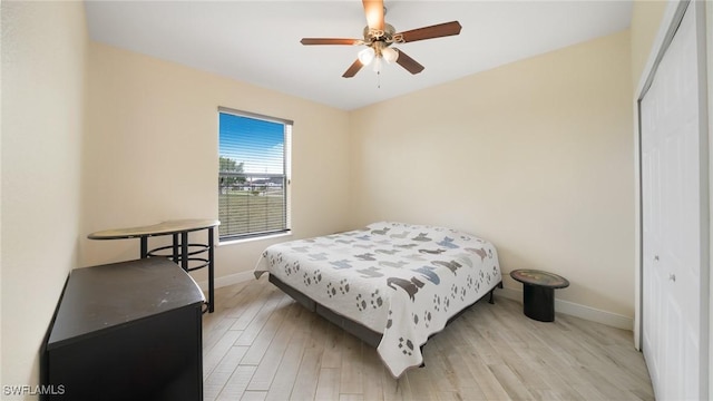 bedroom with light hardwood / wood-style flooring, ceiling fan, and a closet