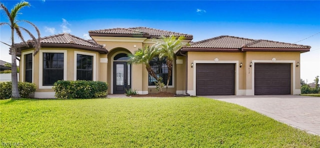 mediterranean / spanish-style house featuring a front yard and a garage