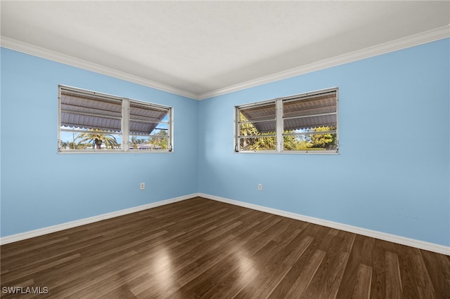 spare room with ornamental molding, baseboards, and dark wood-style floors