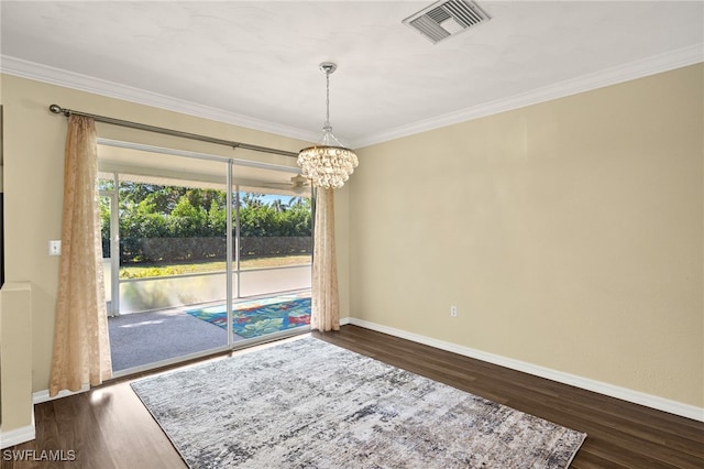 empty room featuring ornamental molding, dark hardwood / wood-style flooring, and a notable chandelier