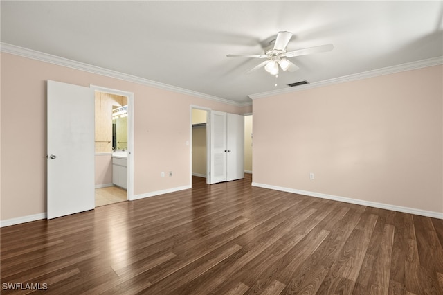 unfurnished bedroom with connected bathroom, ceiling fan, hardwood / wood-style flooring, a walk in closet, and crown molding