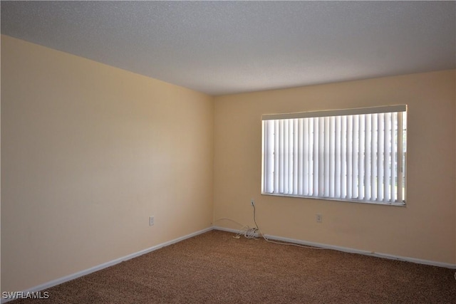 carpeted empty room featuring a textured ceiling