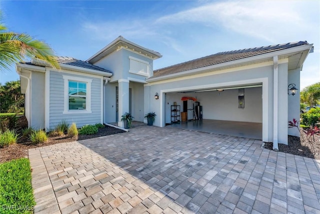 view of front of property with a garage, decorative driveway, and stucco siding