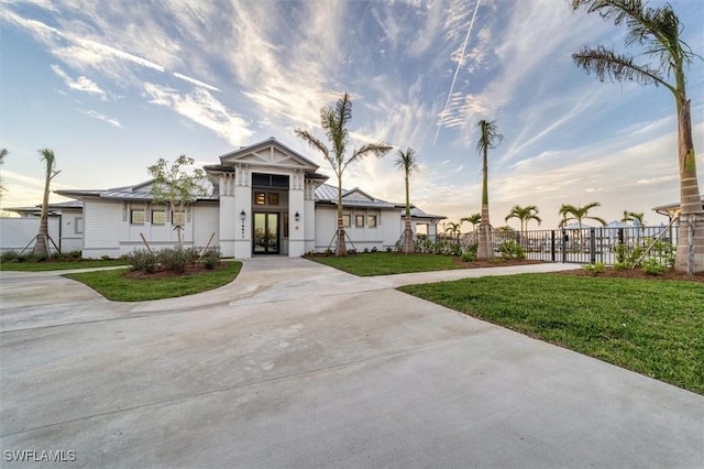 view of front facade with fence, concrete driveway, and a front yard