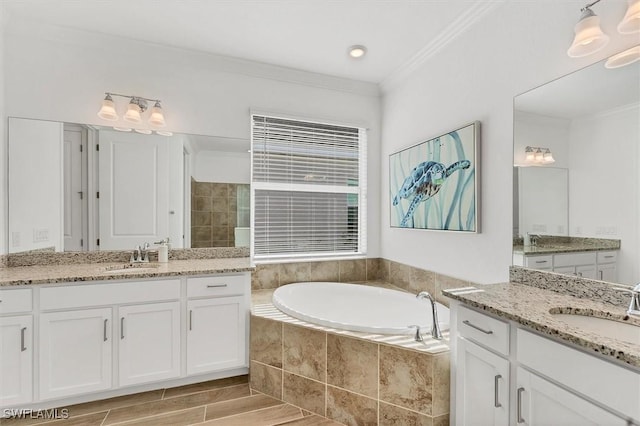 bathroom with a garden tub, ornamental molding, and a sink