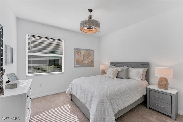 bedroom featuring light carpet and baseboards