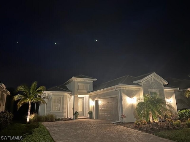 mediterranean / spanish-style home with a garage and decorative driveway