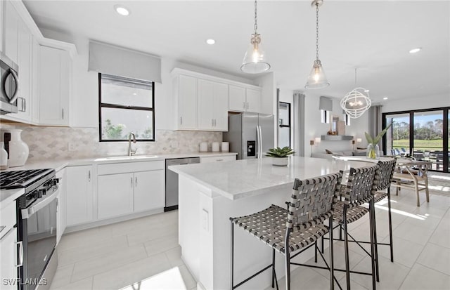 kitchen featuring sink, a kitchen island, white cabinetry, and stainless steel appliances