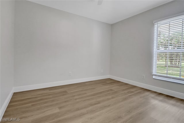 unfurnished room with light wood finished floors and baseboards