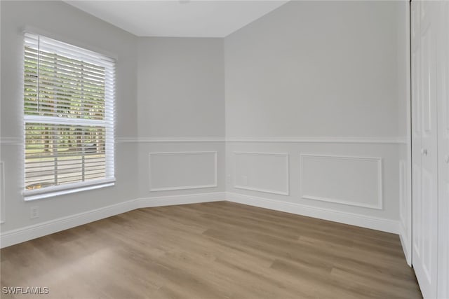 spare room featuring wainscoting and wood finished floors