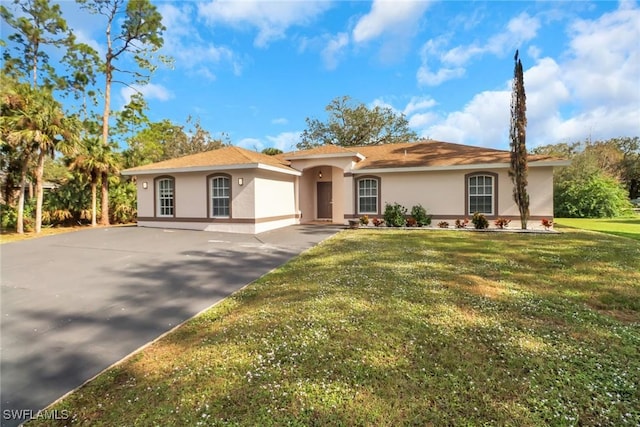 view of front of home with driveway, a front lawn, and stucco siding