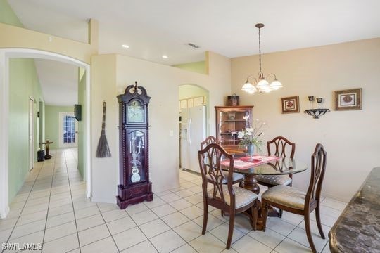 dining area with recessed lighting, arched walkways, a chandelier, and light tile patterned floors