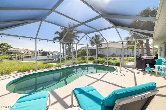 outdoor pool with area for grilling, a lawn, a lanai, a patio area, and a residential view