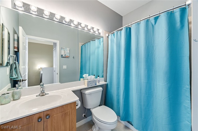 full bathroom featuring a shower with shower curtain, vanity, and toilet