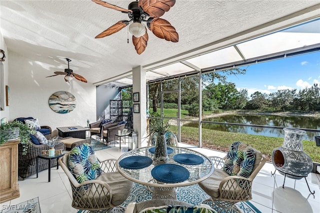 sunroom featuring a water view and ceiling fan