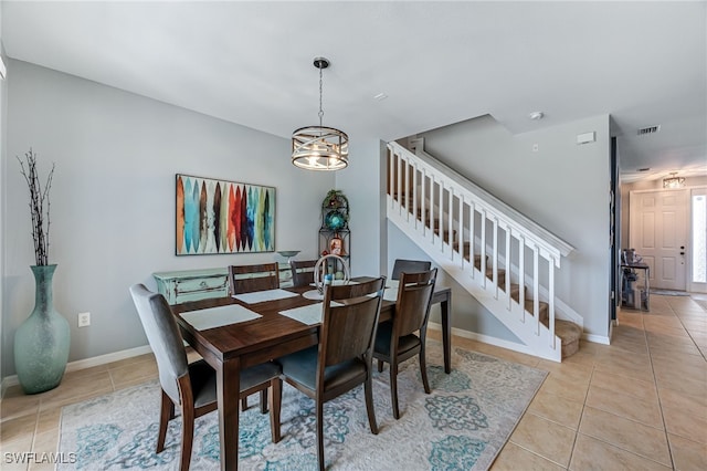 dining space with light tile patterned floors, visible vents, stairway, and a notable chandelier