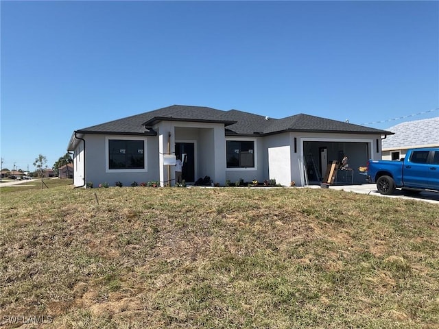 view of front of house featuring a front yard, concrete driveway, an attached garage, and stucco siding