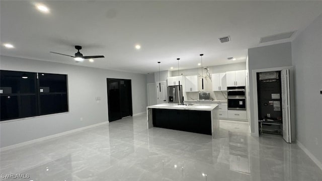 kitchen with visible vents, an island with sink, light countertops, white cabinets, and stainless steel appliances