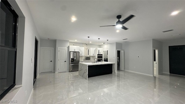 kitchen featuring open floor plan, marble finish floor, stainless steel refrigerator with ice dispenser, and light countertops