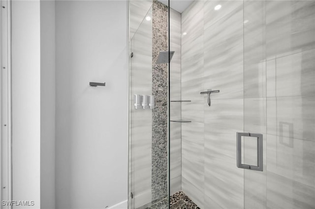 bathroom featuring a shower with door