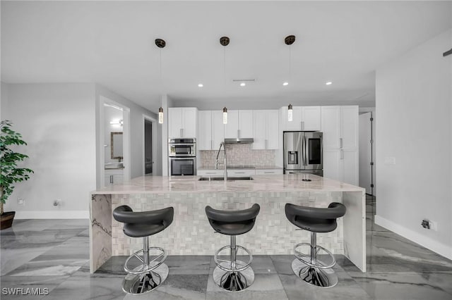 kitchen with a breakfast bar, sink, a large island, stainless steel appliances, and hanging light fixtures